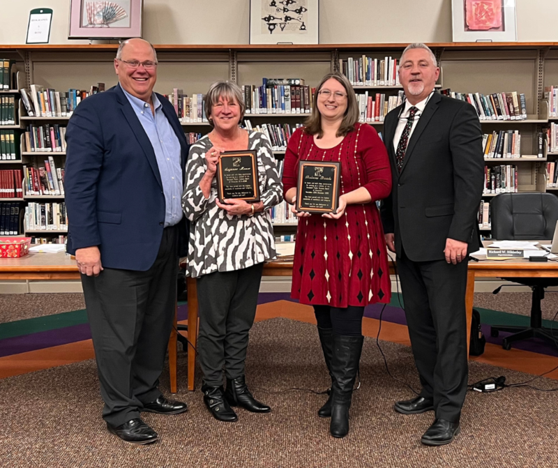 Superintendent Hilderley (far right) joins board president Tony Rebottaro in honoring Suzanne Moore and Rebecca Brooks